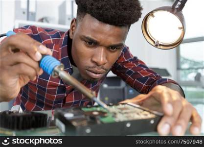 man solders a chip in a workshop