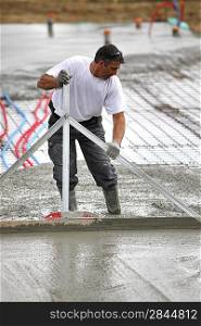 Man spreading wet cement