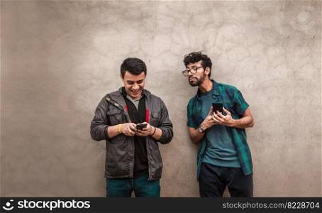 Man spying on another guy cell phone near him. Gossipy man spying on his friend cell phone. Man spying on his friend cell phone near him.