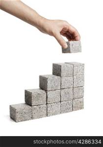 Man stacking blocks made of granite rock.