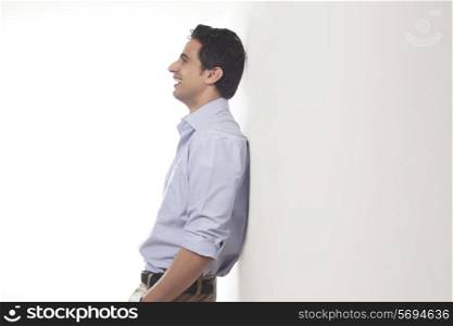 Man standing against a wall smiling