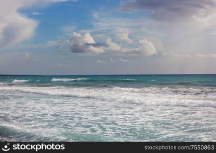 Man standing against the sea on a pier with big wave beating with splash in a storm weather