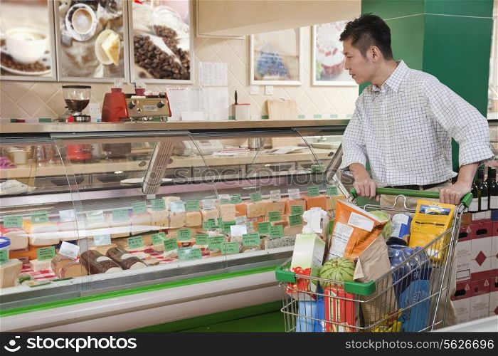Man standing and looking at the Deli counter, Beijing