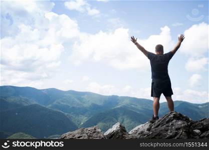 man standing at the edge of rock