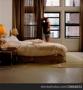 Man standing at window in bedroom