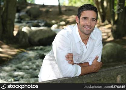 Man standing by a woodland stream