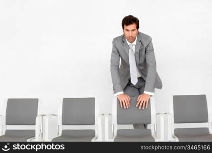 Man standing by chairs in waiting room