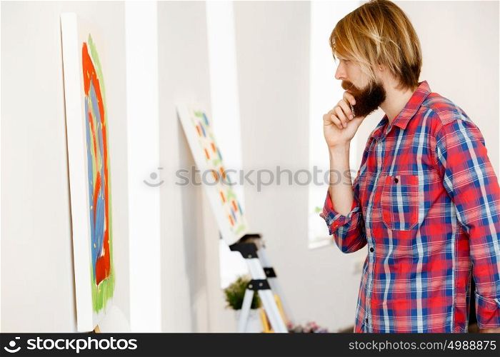 Man standing in a gallery and contemplating artwork. Man standing in a gallery and contemplating abstract artwork