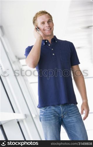 Man standing in corridor wearing headset smiling
