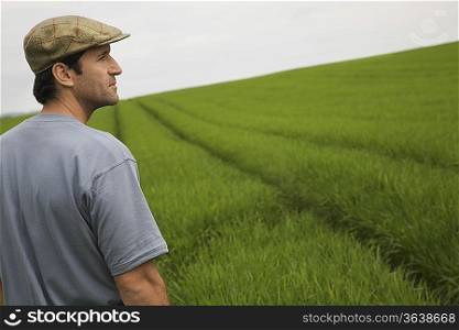 Man standing in field, side view