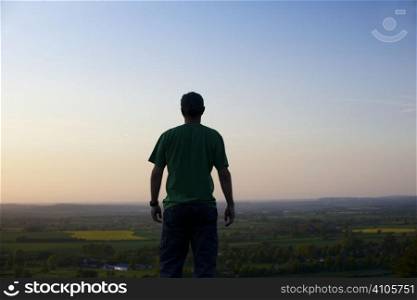 Man standing in front of landscape at dusk
