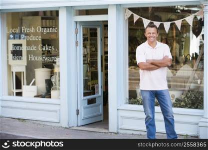 Man standing in front of organic food store smiling
