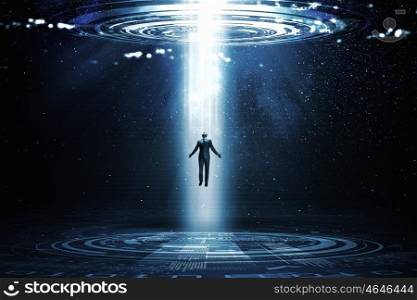 Man standing in light. Businessman with hands spread apart standing in light coming from above