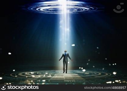 Man standing in light. Businessman with hands spread apart standing in light coming from above