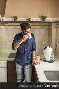 man standing kitchen drinking coffee