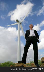 Man standing next to a wind turbine