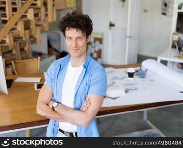 Man standing next to his desk in office