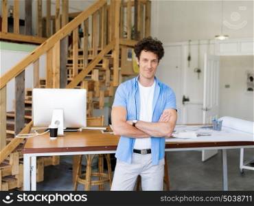 Man standing next to his desk in office