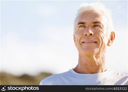 Man standing on beach in sports wear. Man standing on beach in sports wear looking fit and happy
