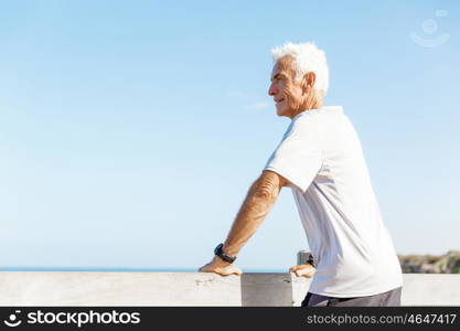 Man standing on beach in sports wear. Man standing on beach in sports wear looking fit and happy