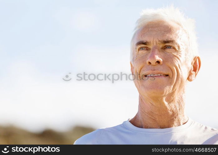 Man standing on beach in sports wear. Man standing on beach in sports wear looking fit and happy