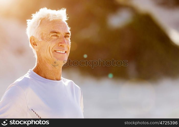 Man standing on beach in sports wear. Man standing on beach in sports wear looking fit and happy