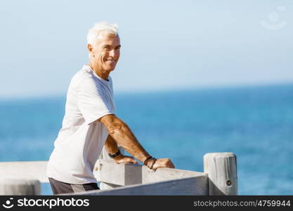 Man standing on beach in sports wear. Man standing on beach in sports wear looking fit and happy