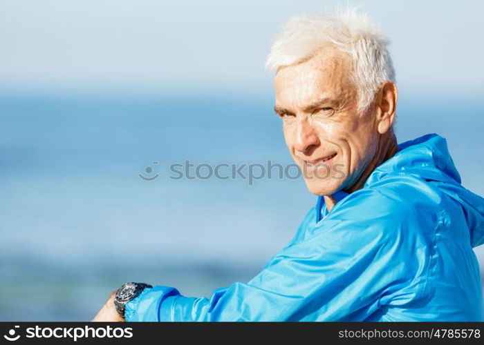 Man standing on beach in sports wear. Man standing on beach in sports wear looking fit and happy