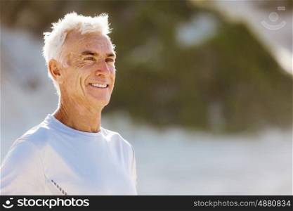 Man standing on beach in sports wear. Man standing on beach in sports wear looking fit and happy
