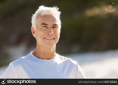 Man standing on beach in sports wear. Man standing on beach in sports wear looking fit and happy