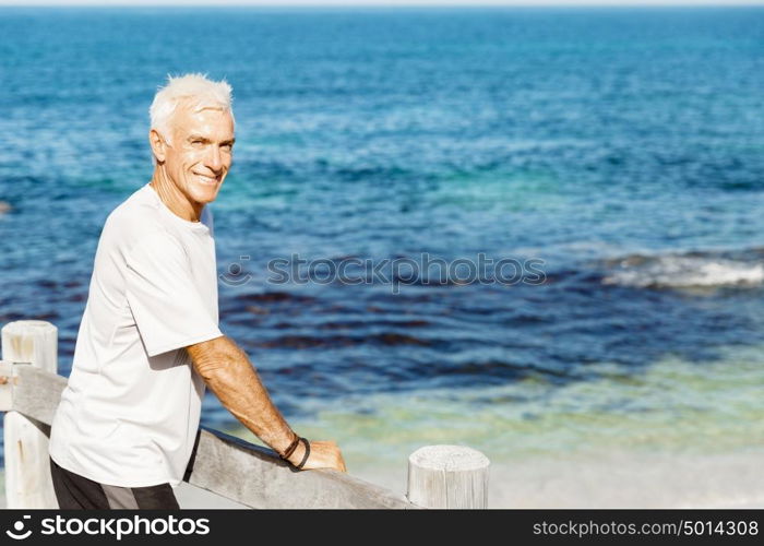 Man standing on beach in sports wear. Man standing on beach in sports wear looking fit and happy