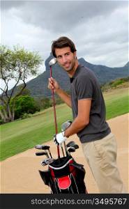 Man standing on golf course with equipment