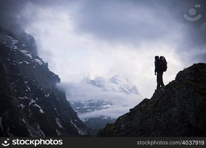 Man standing on rocks with Mount Eiger in background, Bernese Oberland, Switzerland