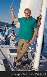 Man Standing on Sailboat with Friends