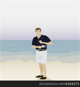Man standing on the beach and holding a camera