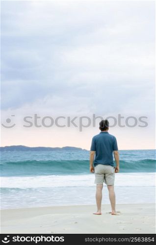 Man standing on the beach contemplating the sea