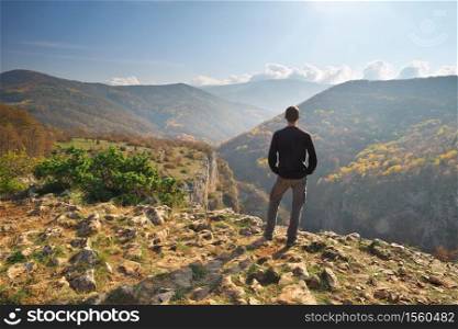 Man standing on the cliff. Conceptual scene. Mountain nature composition.