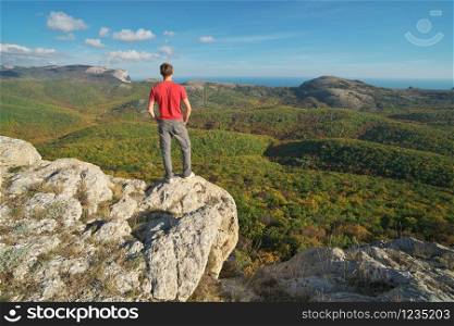 Man standing on the edge of cliff mountain. Conceptual scene.