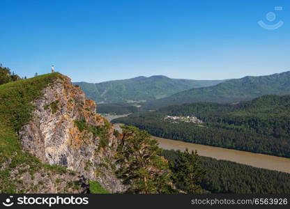 Man standing on top of cliff. Man standing on top of cliff in summer beauty day in Altai mountains