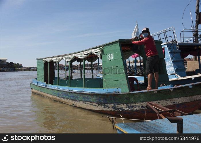 Man standing on tourboat in Tonle Sap lake, Kampong Phluk, Siem Reap, Cambodia . Man standing on tourboat in Tonle Sap lake, Kampong Phluk, Siem Reap, Cambodia