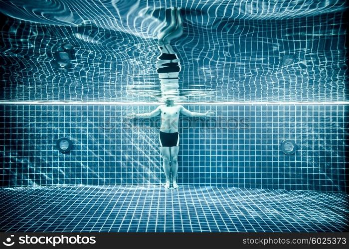 Man standing under water in a swimming pool