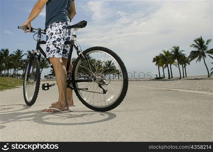 Man standing with his bicycle on the road