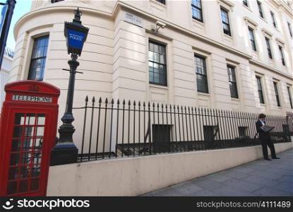 Man stands on London street with red telephone box