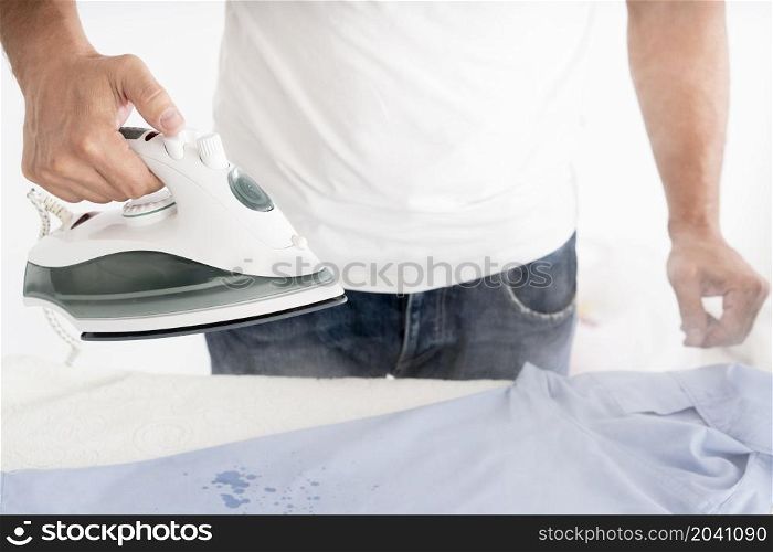 man steaming clothes with clothing iron
