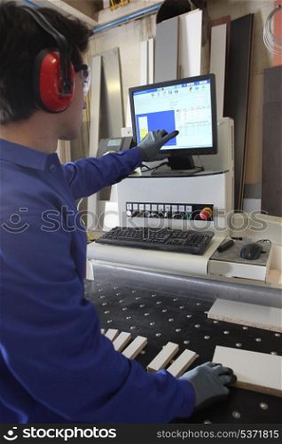Man stood by computer operated factory machine