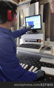 Man stood by computer operated factory machine