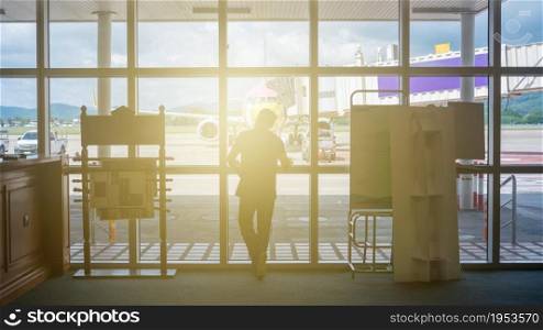 Man Stood In Front Of The Glass Wall In The Airport Lounge With Soft Light.