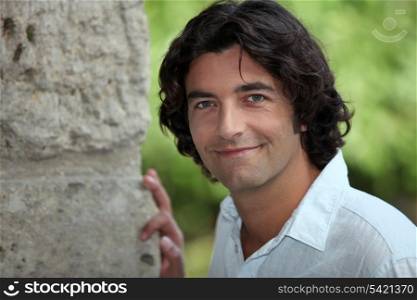 Man stood outdoors by stone wall