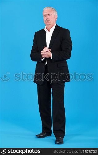 Man stood with hands clasped
