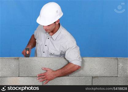 Man straightening brick wall